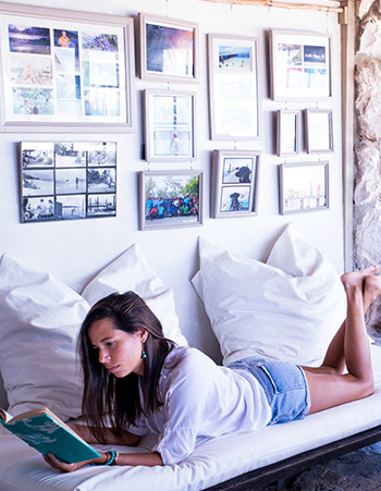 woman reading in the lounge under photos of andros