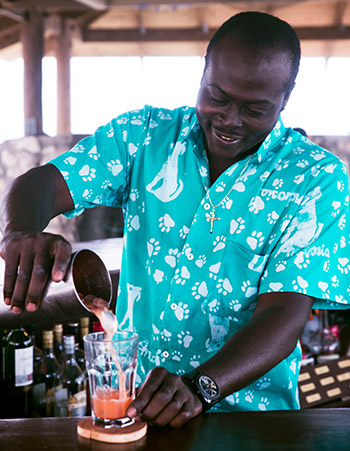 man happily mixes a tropical drink